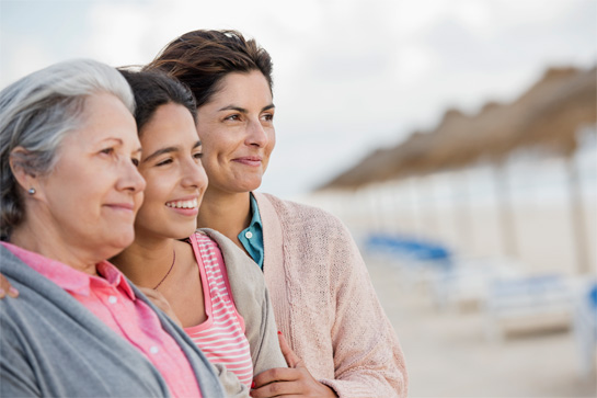 Tres mujeres de distintas generaciones vistas de perfil con rostros esperanzados.